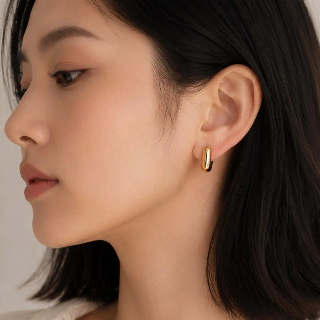 Solène Huggie Earrings gold sculptural close-up stainless steel — Tamola Jewellery